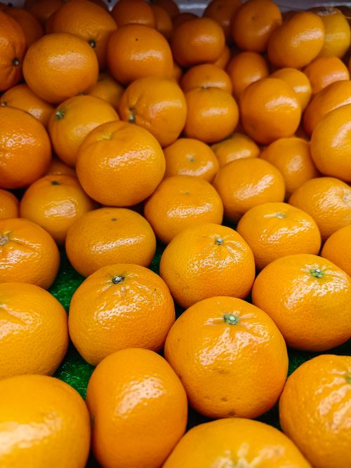 Free Close-up of a vibrant display of fresh, ripe mandarins at a grocery store, perfect for healthy eating. Stock Photo