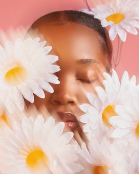 A serene portrait of a woman surrounded by daisies, blending nature and beauty.