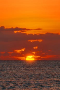Stunning sunset view over Akumal Beach, Quintana Roo, México with vivid orange and yellow sky.