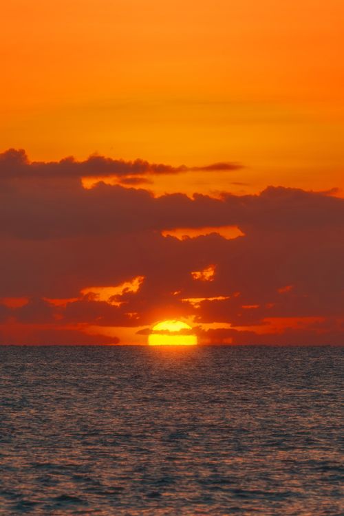Free Stunning sunset view over Akumal Beach, Quintana Roo, México with vivid orange and yellow sky. Stock Photo