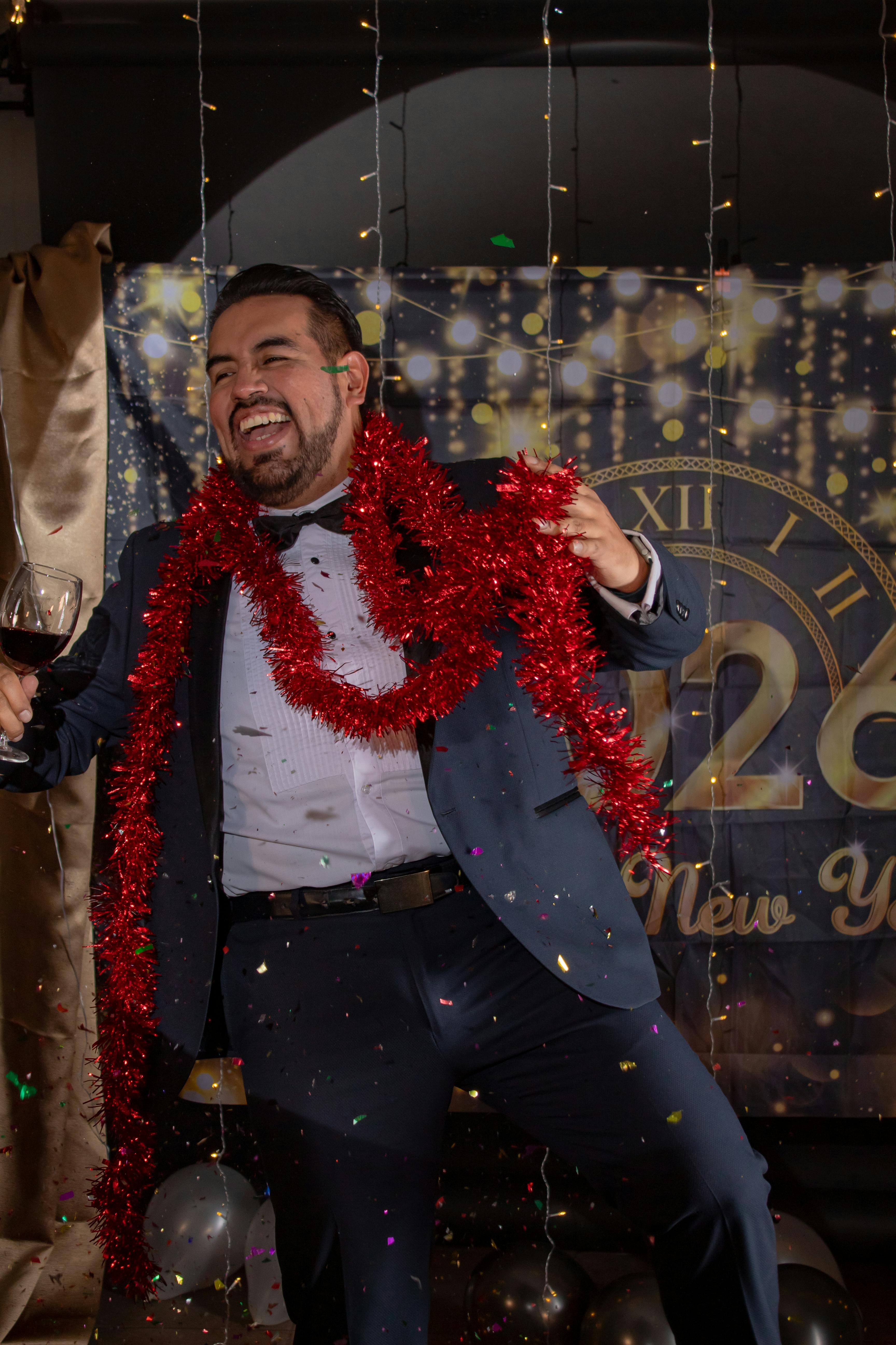 Joyful man celebrating New Year's Eve at a party in Mexico, surrounded by decorations.