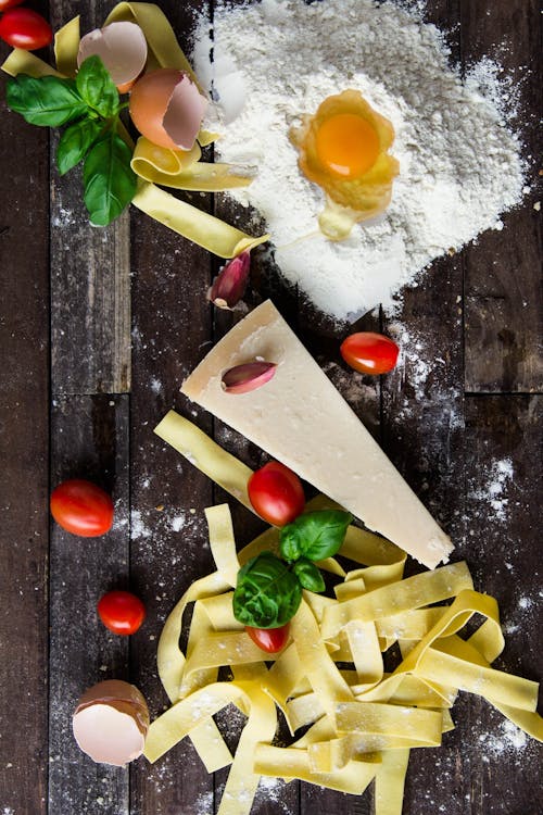 Free Pasta Tomatoes and Flour With Egg Shells on Table Stock Photo