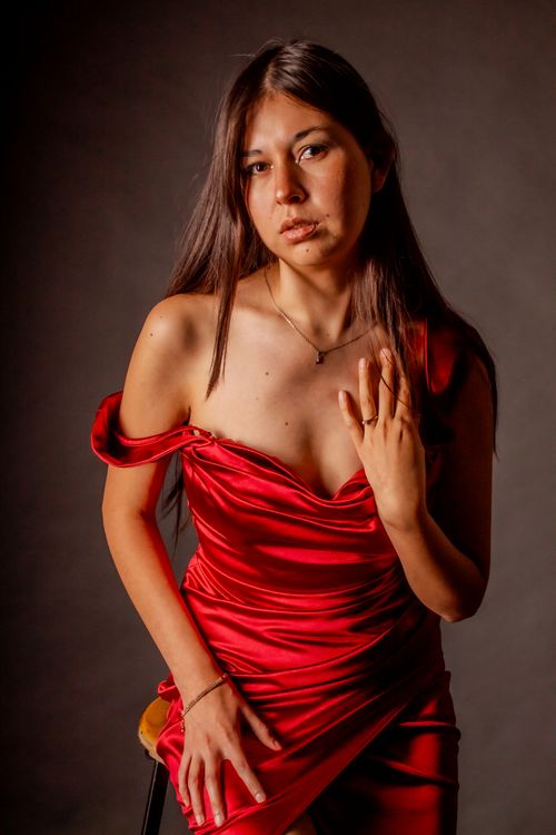 Free Stunning portrait of a woman in a red dress, capturing elegance and style in a studio setting. Stock Photo
