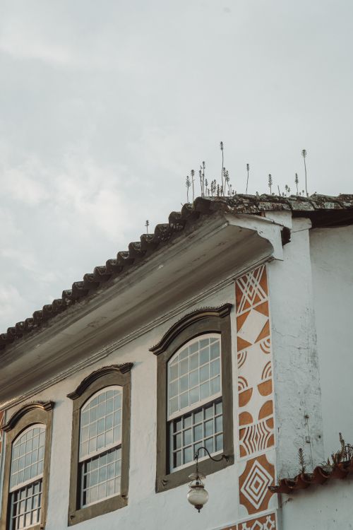 Free A picturesque historic building facade featuring decorative geometric patterns and rustic architecture against a soft sky. Stock Photo