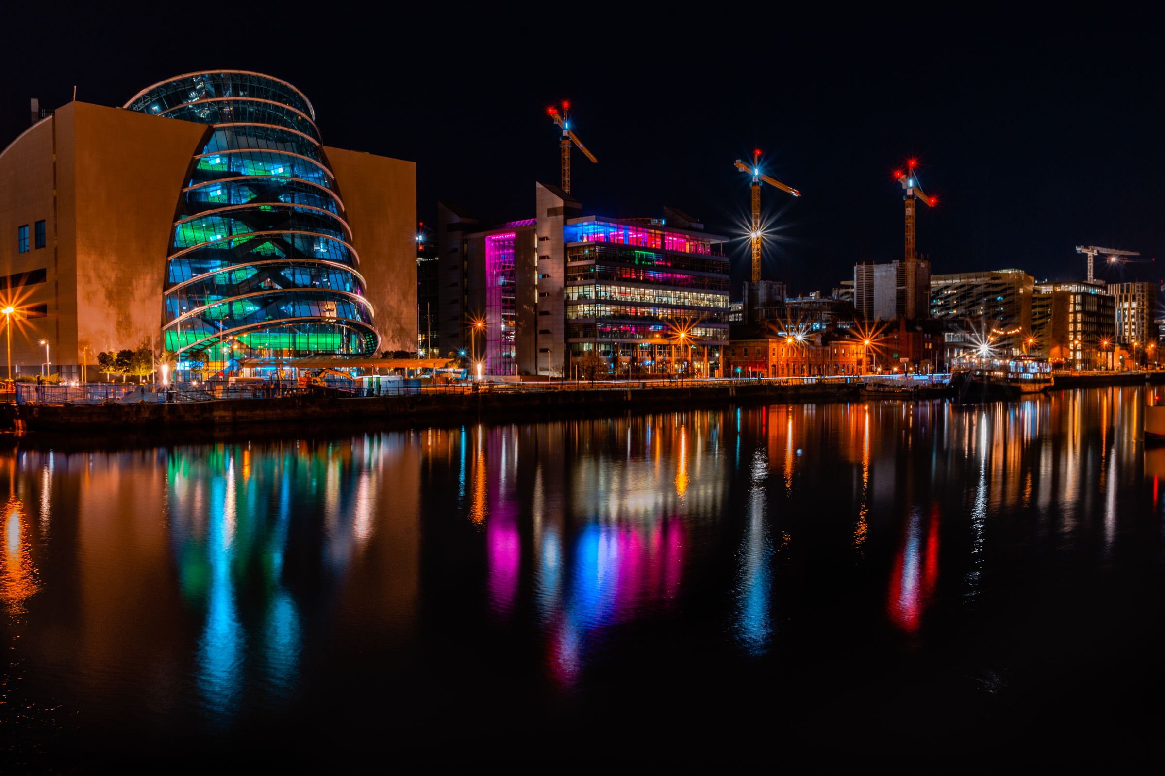 Night view of Dublin's skyline with colorful reflections on the river