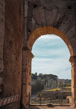 A captivating view of the Roman Forum through an archway of the Colosseum in Rome.