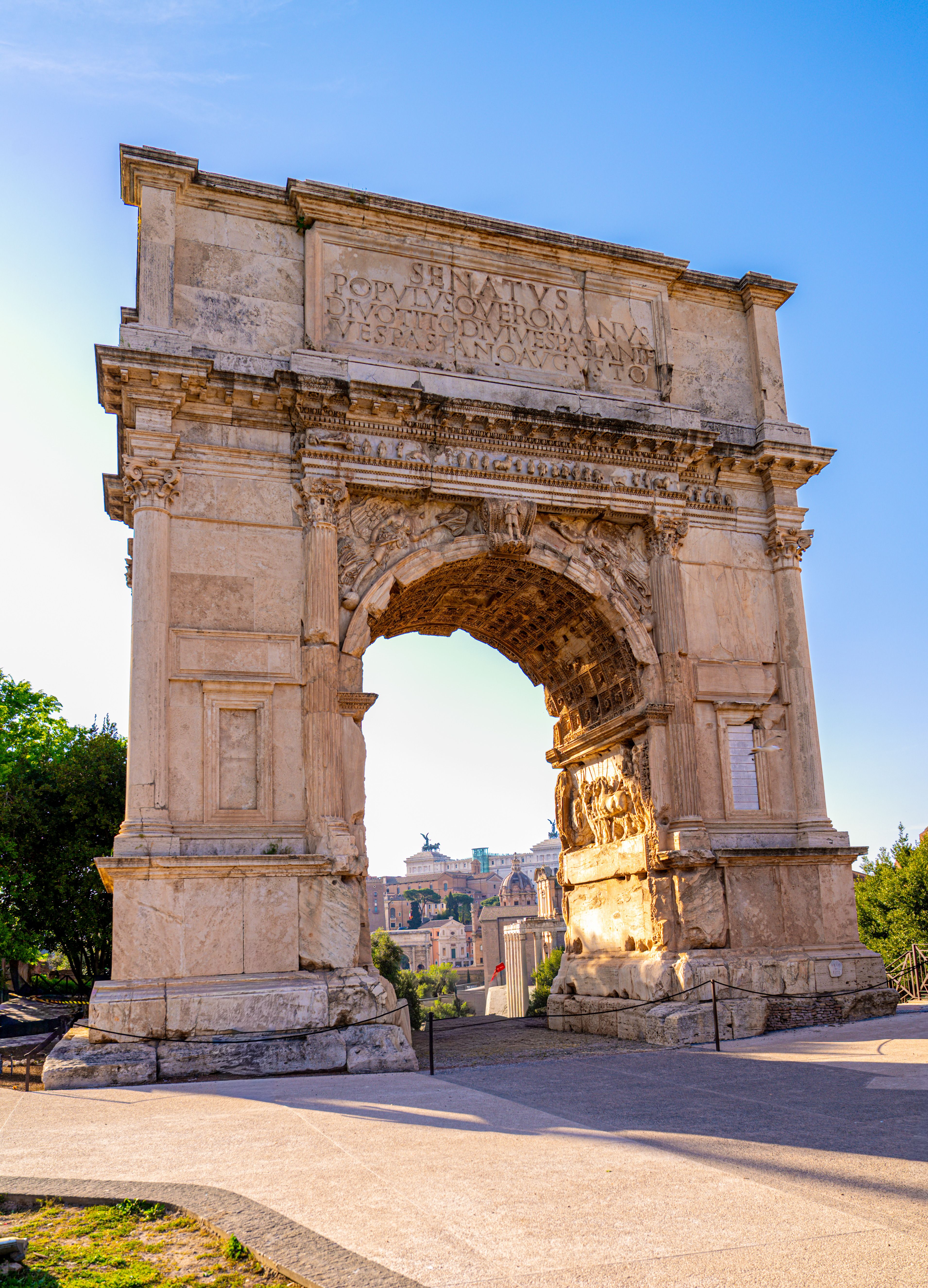 The Arch of Titus stands majestically in the Roman Forum, showcasing ancient Roman architecture.