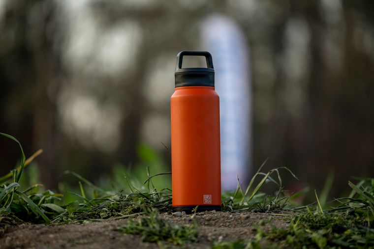 Bright flask resting on sunlit grass — photo by Stephen Leonardi on Pexels