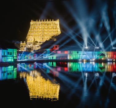 Stunning nighttime illumination at Padmanabhaswamy Temple with vibrant reflections.