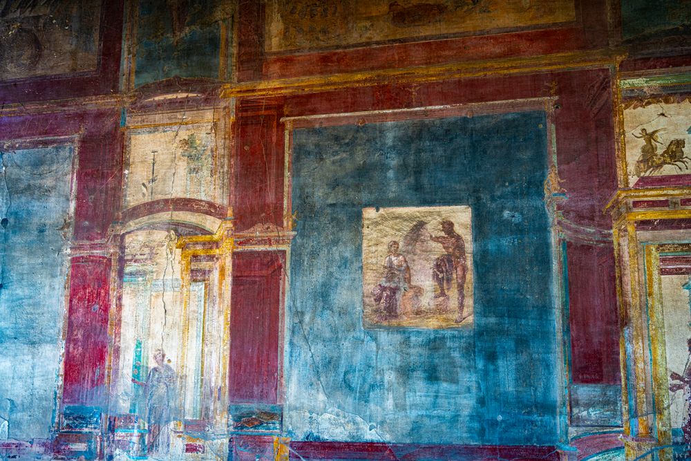 Perete cu fresce romane în roșu, albastru și ocru, în stil pompeian
