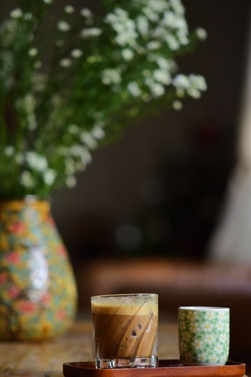 Free Aesthetic indoor coffee setup with stylish vase and floral focus. Stock Photo