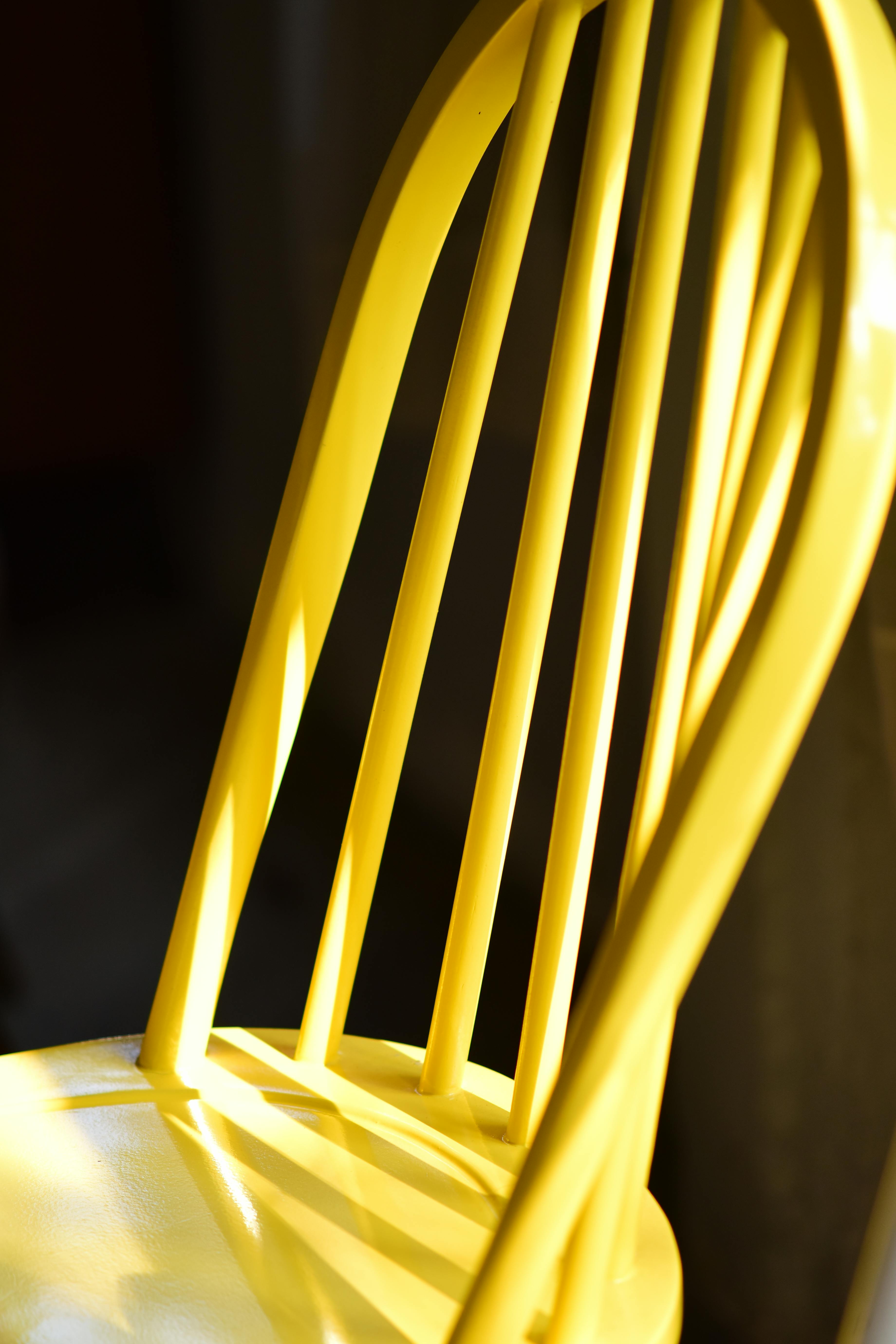 Gratis En livlig gul stol fanget i dramatisk sollys innendørs, som kaster skygger. Arkivbilde