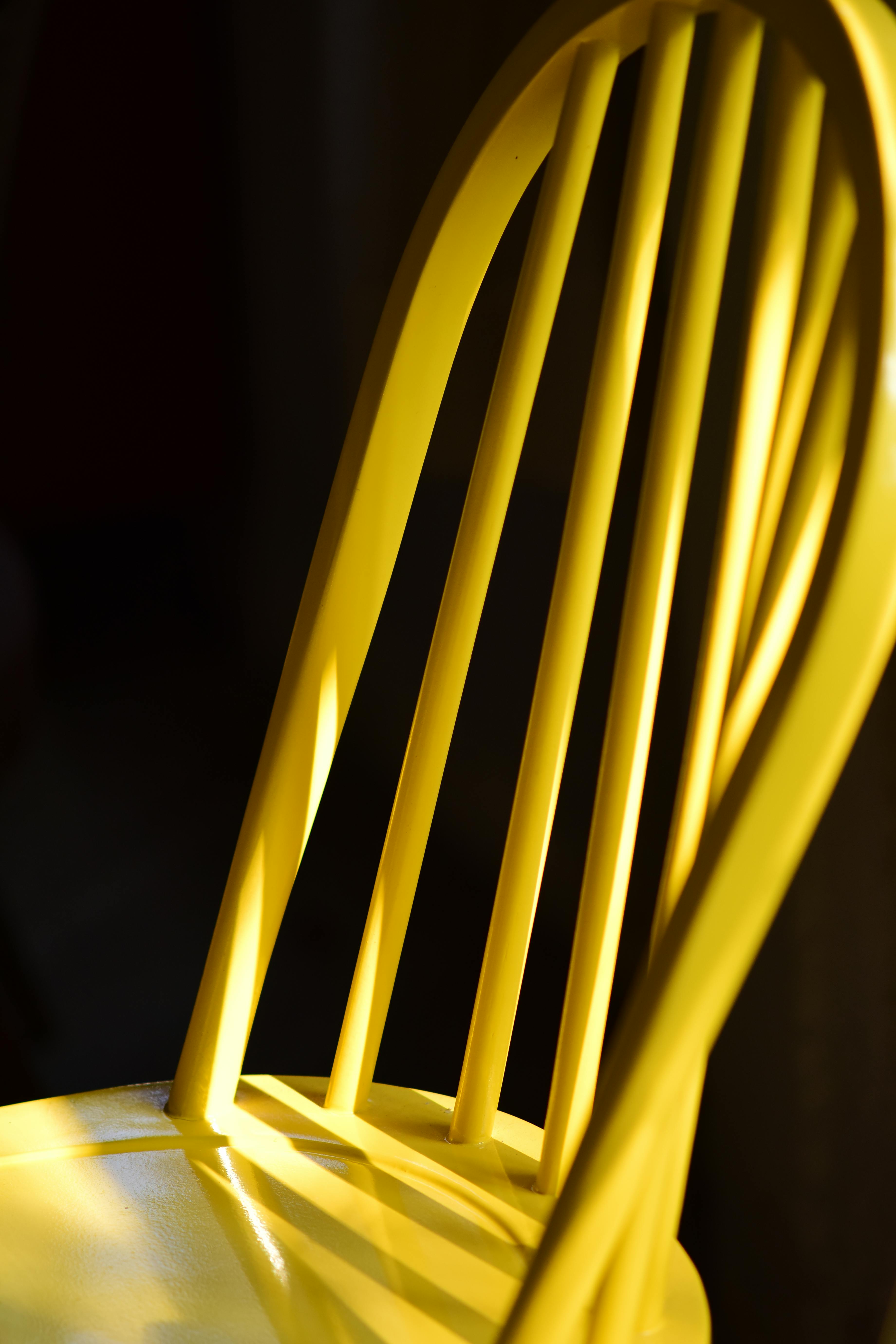 Gratis En knallgul trestol kaster skygger i dramatisk belysning, og skaper en kunstnerisk komposisjon. Arkivbilde