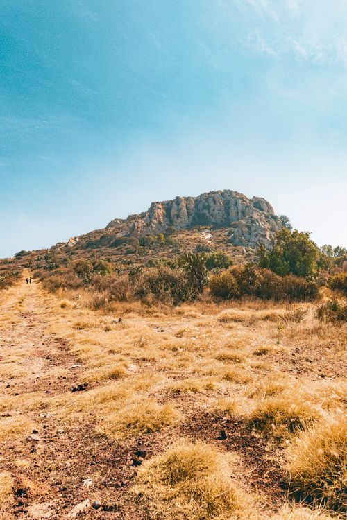 Free A tranquil mountain landscape with dry grasslands under a bright blue sky, perfect for nature enthusiasts. Stock Photo