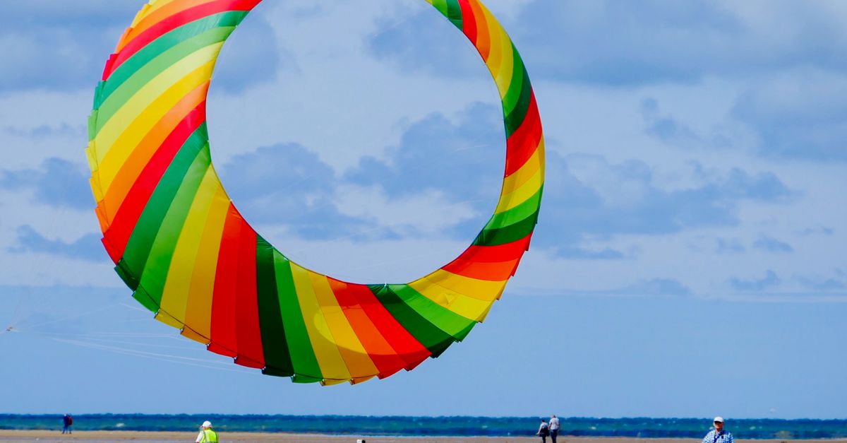 Vibrant rainbow kite soaring at Lytham St Annes beach. Perfect day for kite flying.
