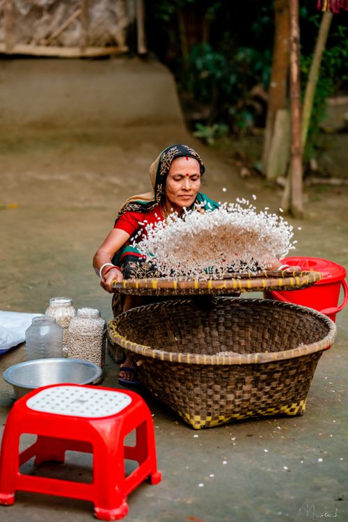 Woman Sifting Rice Outdoors in Rural Setting · Free Stock Photo
