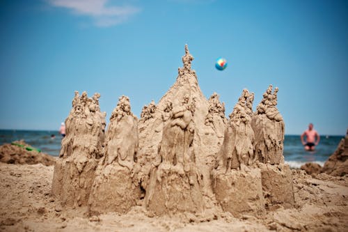 Sand Sculpture on Beach Under Blue Sky