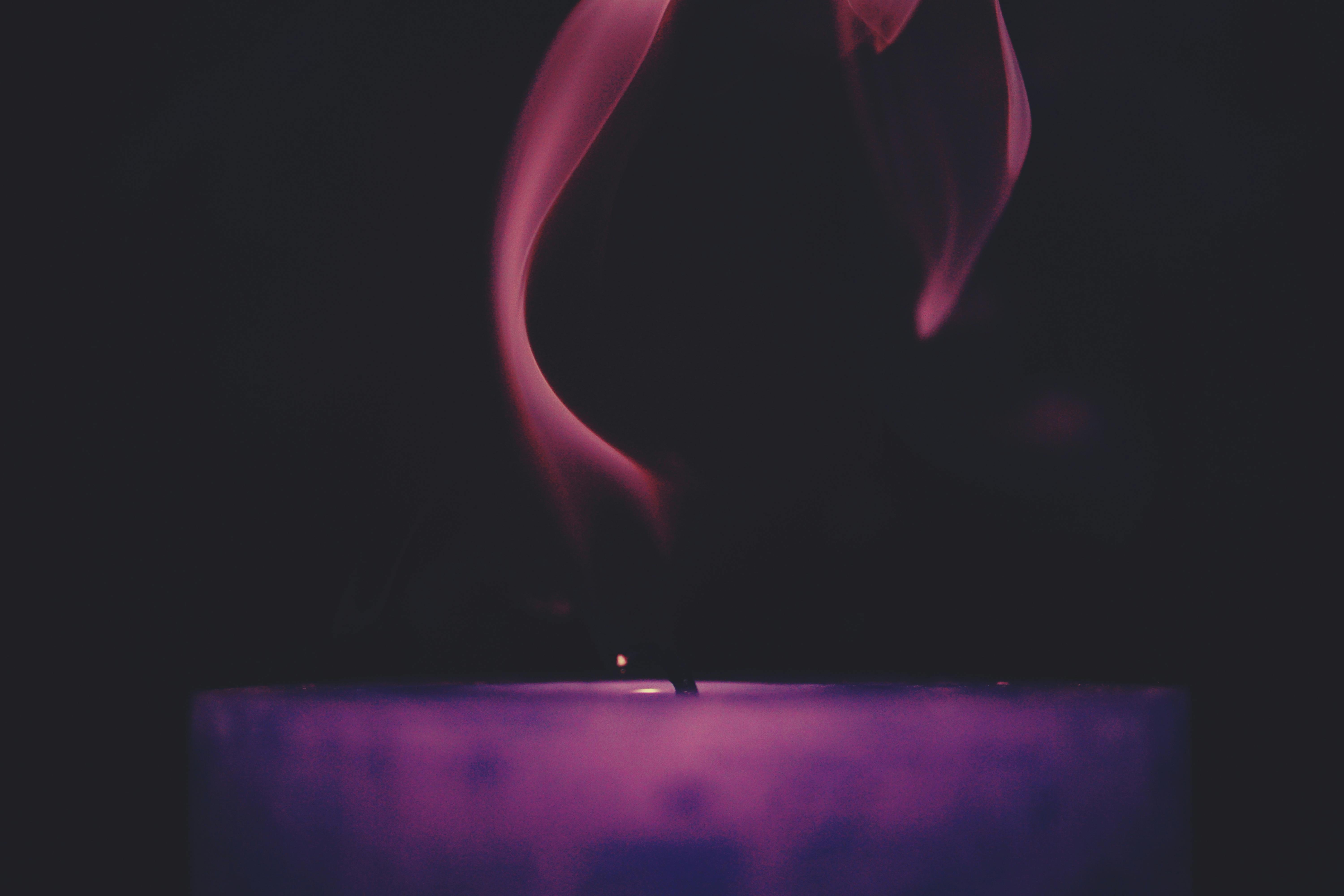 Lighted Purple Candle Against Black Background · Free Stock Photo