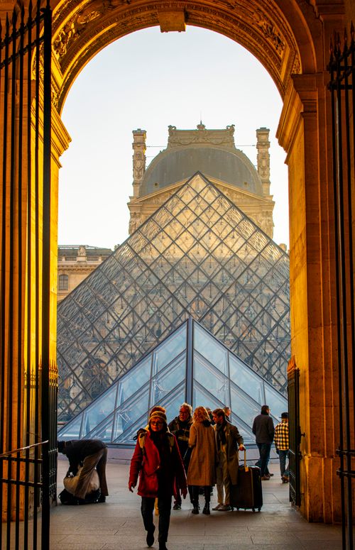 Free People enjoying a sunny day at the famous Louvre Pyramid in Paris, France. Stock Photo