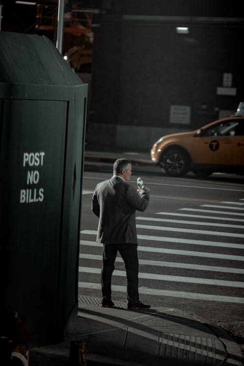 Man in Gray Suit Waiting on Pedestrian Lane