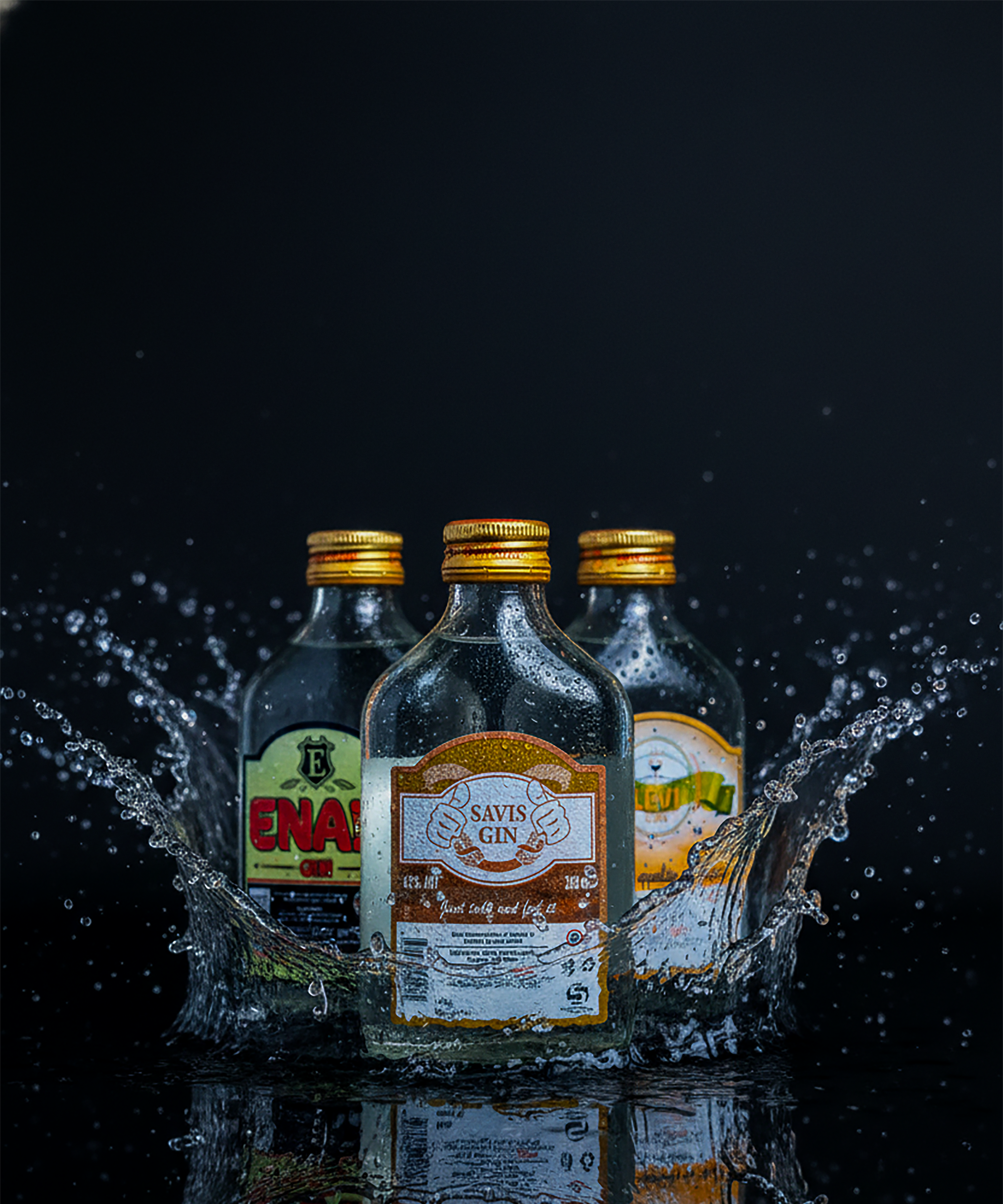 Three bottles of gin with golden caps in a dynamic splash against a dark background.