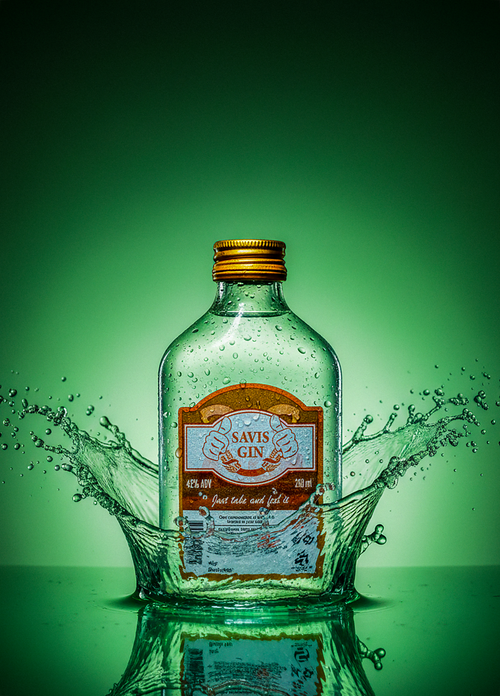 Free A dramatic splash around a Savis Gin bottle with a green backdrop. Stock Photo