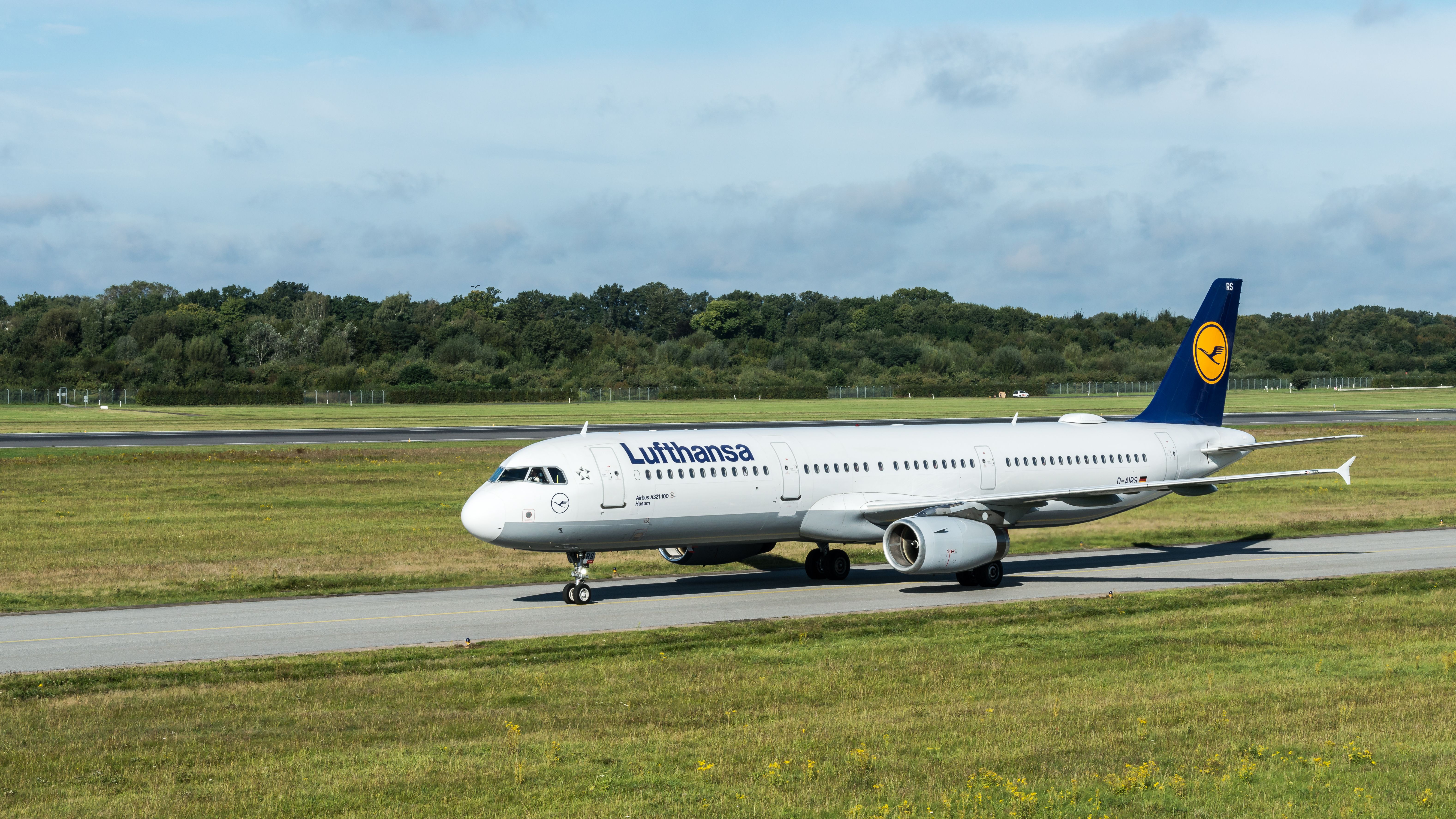 Gratis Lufthansa-fly taxier i Hamborg Lufthavn på en klar dag. Lagerfoto