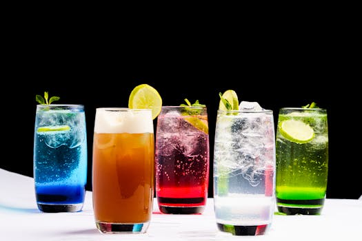 Cocktail vivaci e colorati con guarnizione di agrumi su sfondo nero.