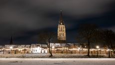 Stunning night view of a historic church in Sittard, Netherlands illuminated with festive lights.