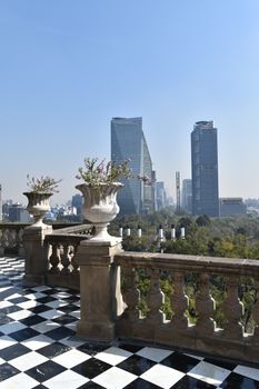 Beautiful view from Chapultepec Castle towards Mexico City's skyline with iconic skyscrapers and blue sky.