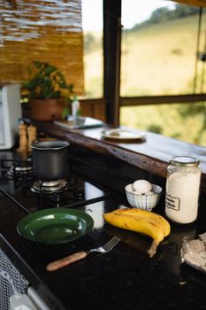 A cozy kitchen setup with bananas, eggs, and rice on a countertop, ready for cooking.