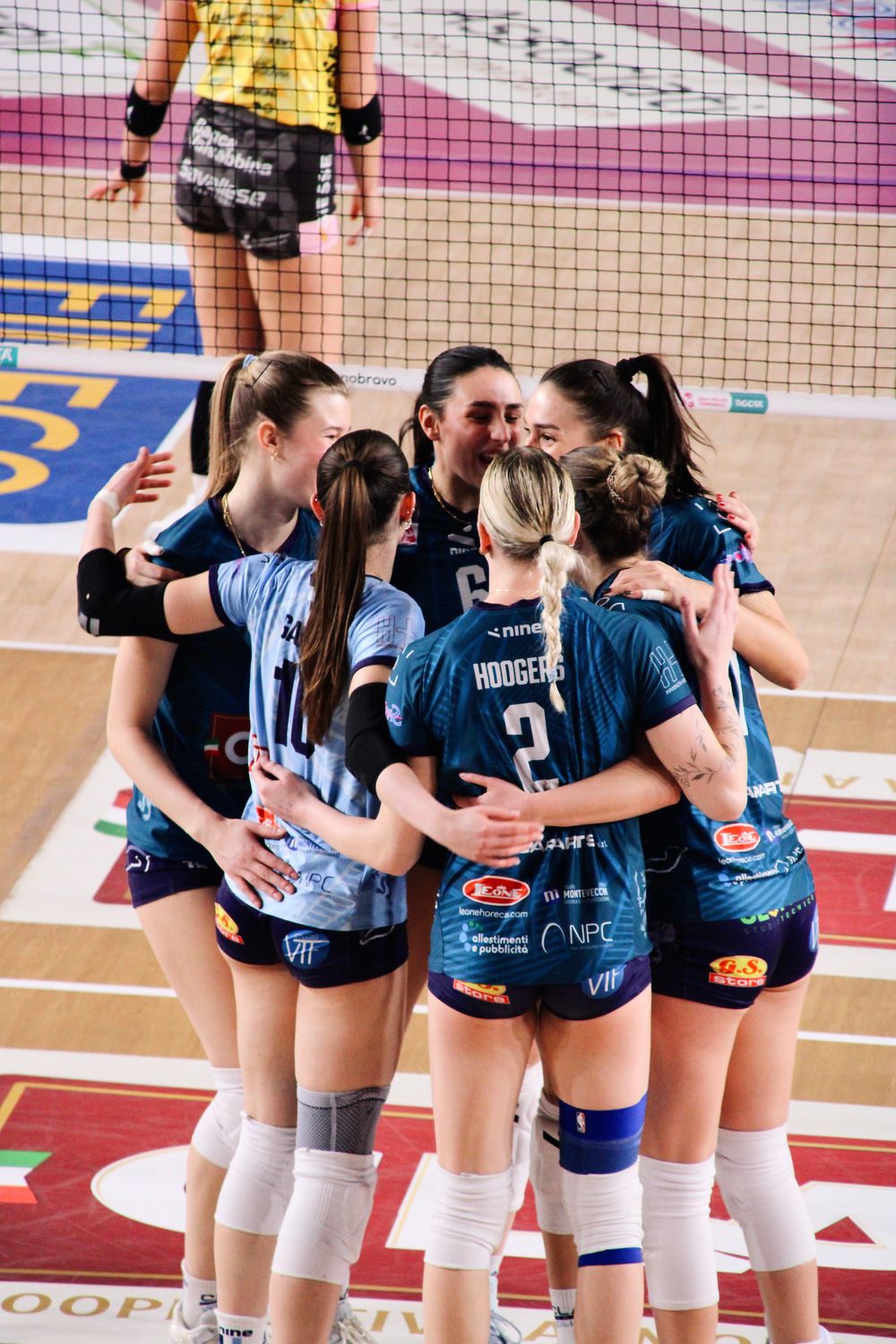 Women’s volleyball team celebrating in coordinated blue jerseys