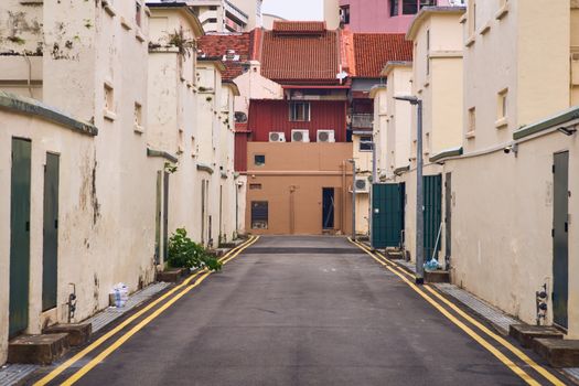 A deserted alleyway lined with historic buildings and colorful rooftops.