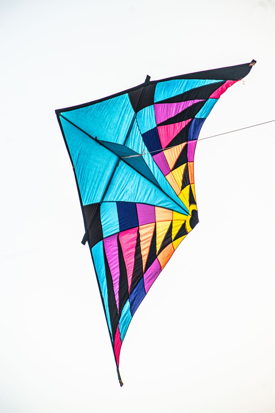 Vibrant multicolored kite soaring in a bright clear sky