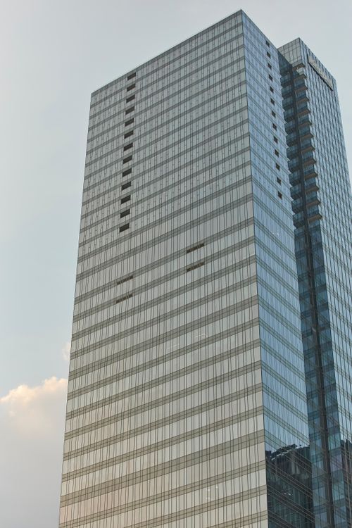 Free A towering glass skyscraper in Ho Chi Minh City at sunset. Stock Photo