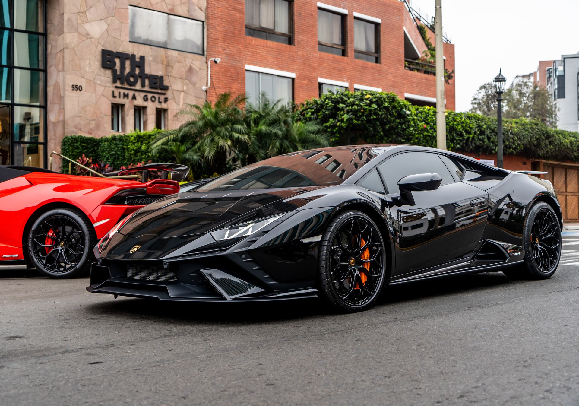 Luxury sports cars in front of a grand hotel