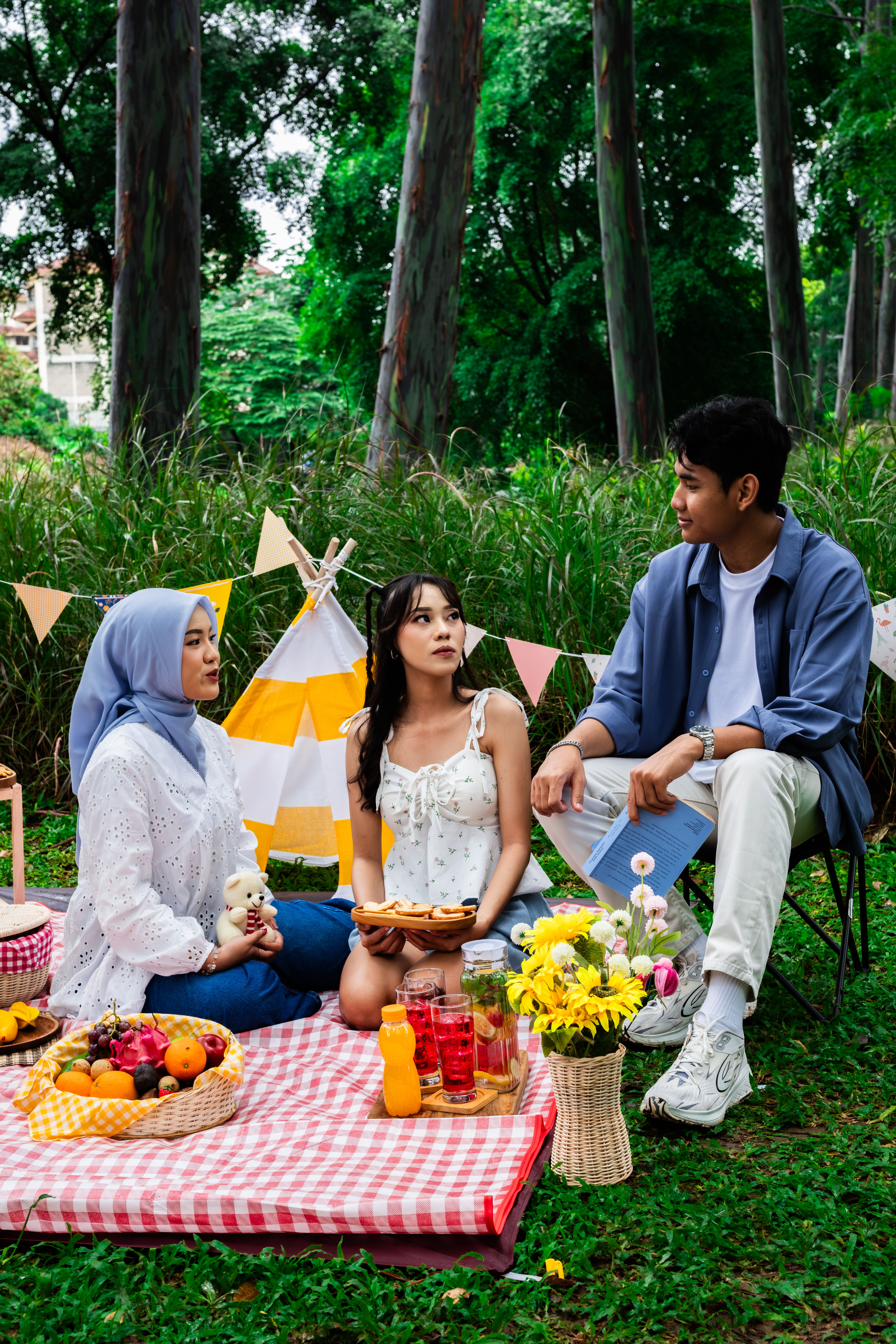 A joyful group of friends having a colorful picnic in a lush Indonesian garden.