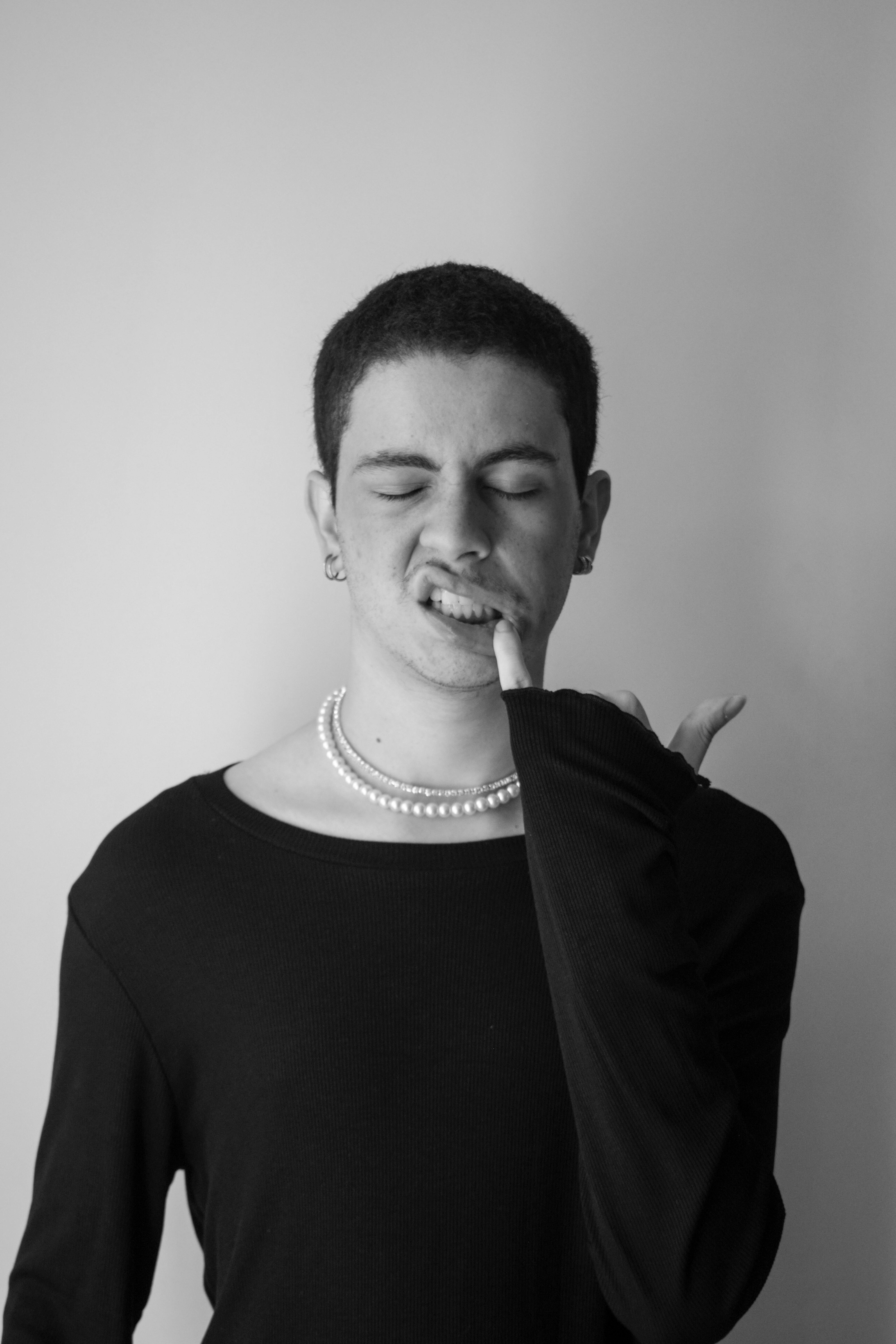 gratis Stijlvol zwart-witportret van een persoon met parels en een unieke uitdrukking. Stockfoto