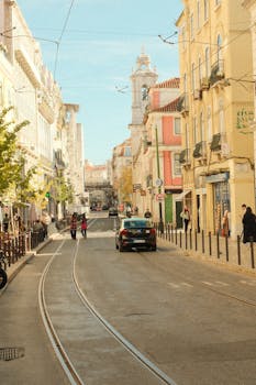Charming Lisbon street scene with tram tracks and historic architecture, highlighting the vibrant city life in Portugal.