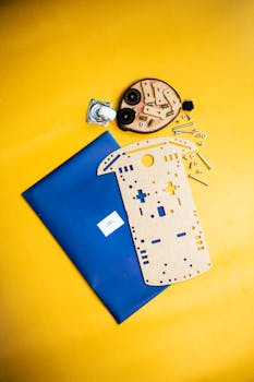 Top view of robotics kit parts on a vibrant yellow surface, ideal for STEM education visuals.