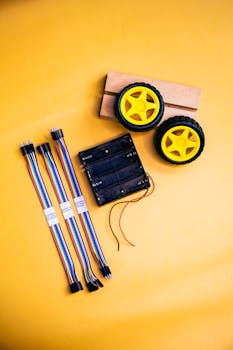 Electronics components for robotics on a bright yellow background. Ideal for tech enthusiasts and educators.