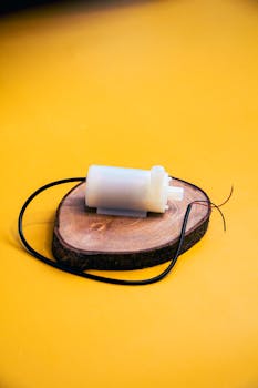 A small electronic component displayed on a wooden base with a vibrant yellow background.