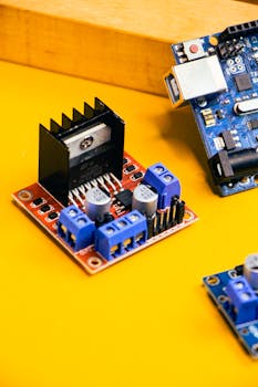 Detailed view of robotics and electronics circuit boards on a vibrant yellow background.