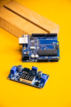 Close-up of electronic components on a yellow surface for modern robotics innovation.