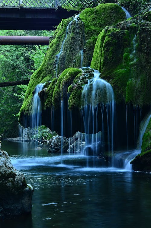 Time-Lapse Photo of Waterfalls in Mossy Rock Formation