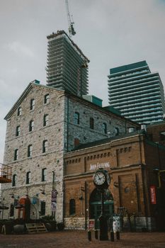 Explore the contrast of historic and modern architecture in Toronto's Distillery District with visible construction.