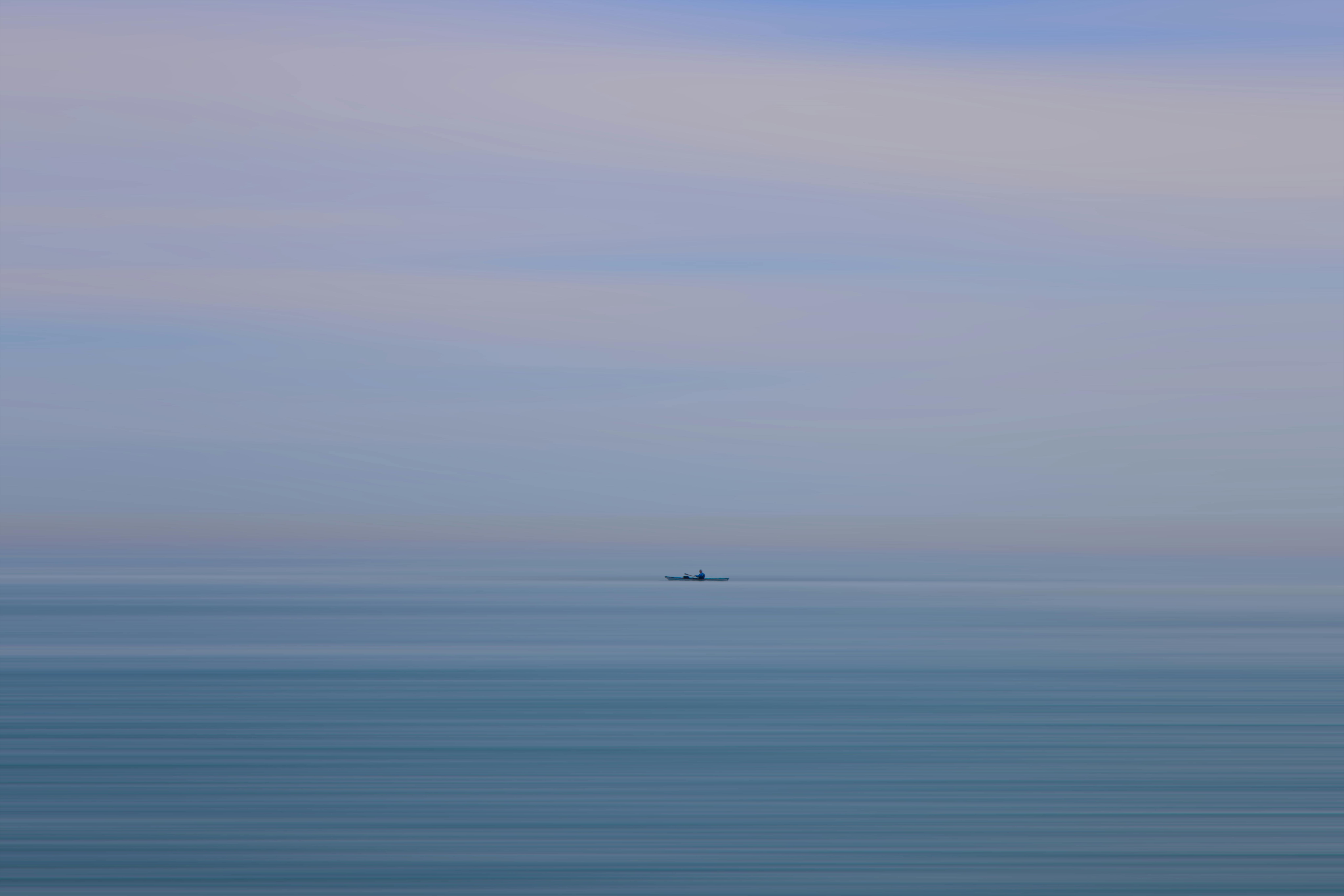 Gratuit Scène paisible d'un kayakiste solitaire sur la mer calme près d'Hastings, sous un ciel aux teintes pastel. Photos