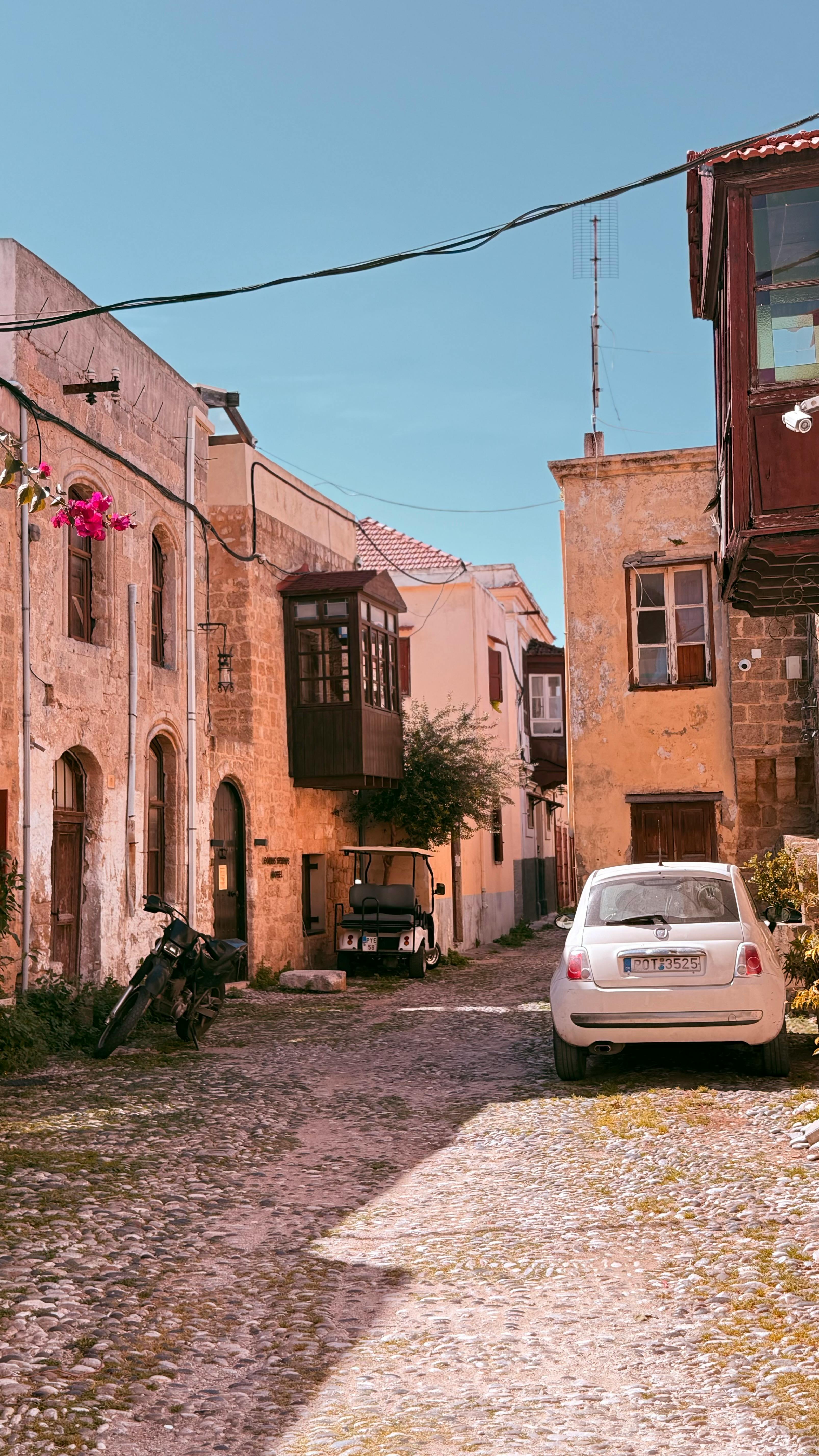 Rustic cobblestone street with vintage buildings in a sunny European town.