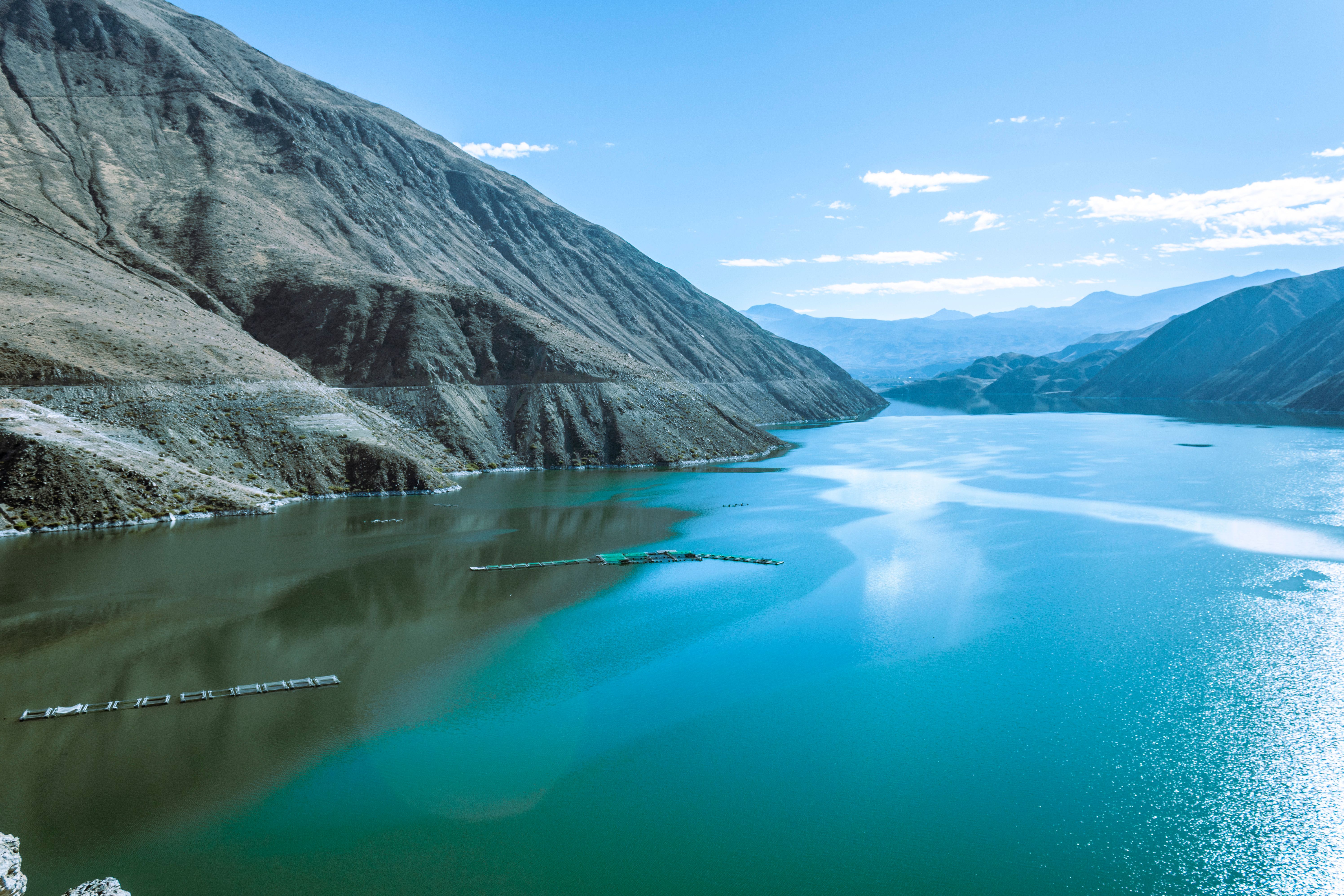 Breathtaking aerial view of the lake and mountains in Tacna, Peru, under a clear blue sky.