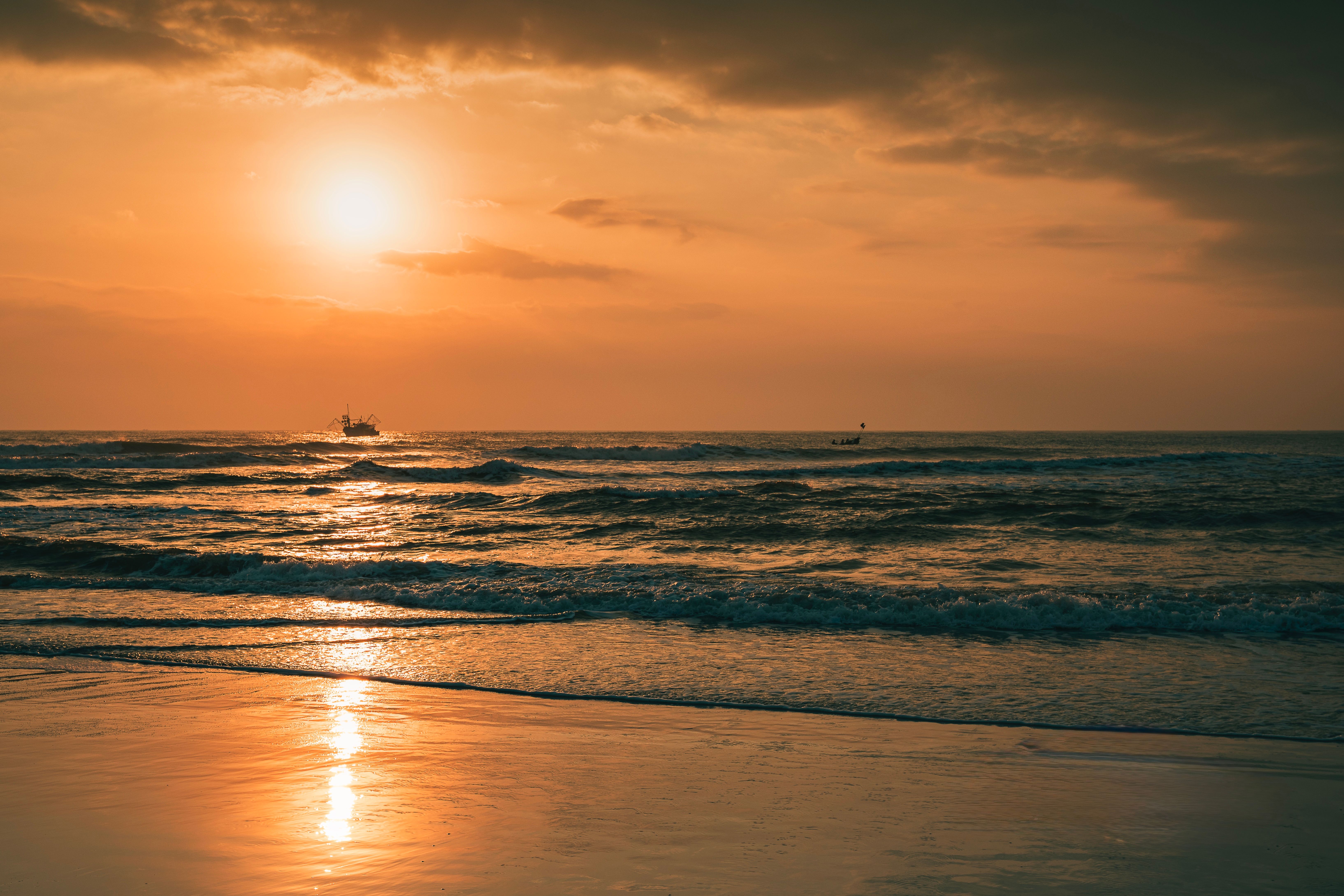 Serene Beach Sunset with Reflective Waves · Free Stock Photo